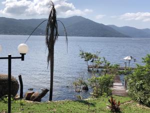 uma vista para um corpo de água com uma palmeira em Casa com Piscina e Acesso a Lagoa da Conceição NG0811 em Florianópolis