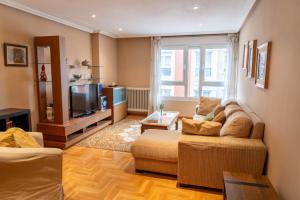 a living room with a couch and a tv at Apartamento Mayte in Siero