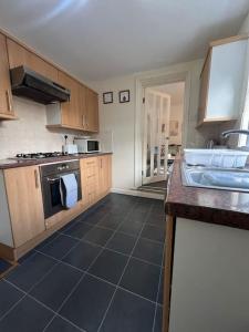 a kitchen with a sink and a stove at Comfortable and spacious home. FREE Parking. in Gateshead