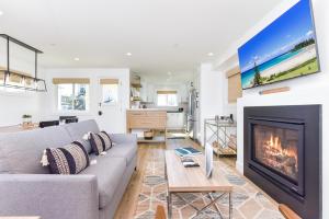 a living room with a couch and a fireplace at BRAND NEW Luxury 1 Bedroom Condo Steps from the Beach in Newport Beach