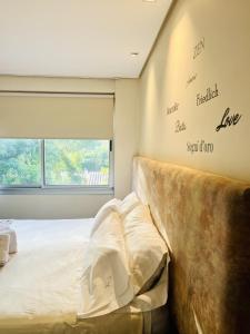 Un dormitorio con una cama grande y una ventana en La Sofia Apart & Wines en Mendoza