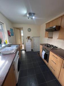 a kitchen with a sink and a stove top oven at Comfortable and spacious home. FREE Parking. in Gateshead