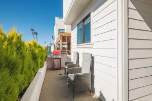 a white building with chairs and a red gas station at BRAND NEW Luxury 1 Bedroom Condo Steps from the Beach in Newport Beach