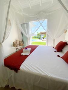 a bedroom with a white bed with a red blanket at Villa du Levant-6/8 pers-Piscine in Saint-François +22 photos