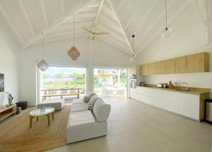 a kitchen and living room with a couch and a table at Villa du Levant-6/8 pers-Piscine in Saint-François