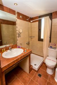 a bathroom with a sink and a toilet and a shower at Thalassies Nouveau in Limenaria