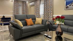 sala de estar con sofá y 2 sofás en JPN SQUARE Douala, en Douala