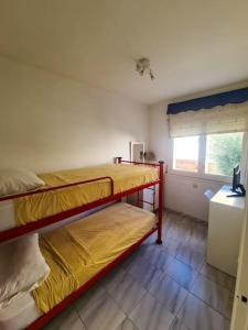two bunk beds in a room with a window at Nice beachside 2-BD apt near Barcelona in Cunit