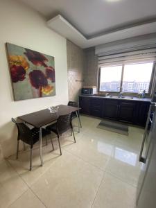 a dining room with a table and chairs and a window at Modern Apart in Heart of Amman in Rujm ash Sharāʼirah