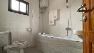 a bathroom with a tub and a toilet and a sink at JPN SQUARE Douala in Douala +54 photos