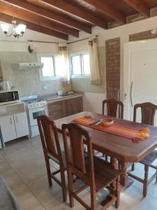 a kitchen with a wooden table and chairs in a room at Los Tres Algarrobos in Cortaderas
