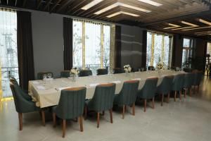 ein langes Esszimmer mit einem langen Tisch und Stühlen in der Unterkunft Andoena Resort in Lipljan