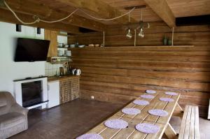 una cocina con paredes de madera y una mesa con alfombras. en Užukalnio sodyba, 