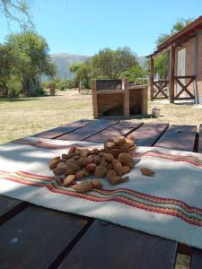 una pila de nueces sentada sobre una mesa de picnic en Los Tres Algarrobos en Cortaderas