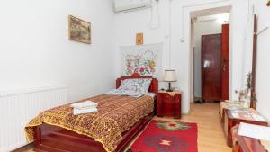 Schlafzimmer mit einem Bett und einem roten Teppich in der Unterkunft Etno Apartmani ''Vlaška kuća'' in Kladovo