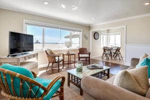 uma sala de estar com um sofá e uma televisão em Beachfront Getaway on the Sand em Newport Beach