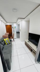 a living room with a couch and a flat screen tv at Apartamento Home Pratice in São Luís
