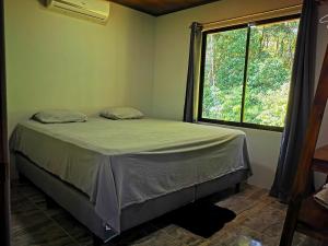 Bett in einem Zimmer mit einem großen Fenster in der Unterkunft Casa Sëlë in Fortuna