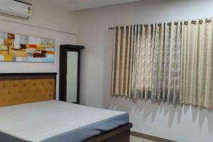 een slaapkamer met een bed en een raam bij Luxurious 3BHK Flat in Magarpatta in Pune