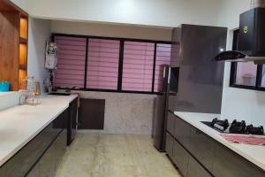 een keuken met roze rolluiken op een raam in een keuken bij Luxurious 3BHK Flat in Magarpatta in Pune
