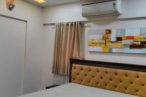 een slaapkamer met een bed en een schilderij aan de muur bij Luxurious 3BHK Flat in Magarpatta in Pune