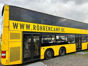 a yellow double decker bus parked in a parking lot at Röhrencamp Schöten/Apolda in Apolda