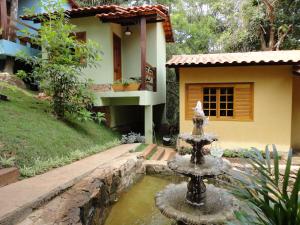 a water fountain in front of a house at Pousada Aquarela - Macacos in Macacos