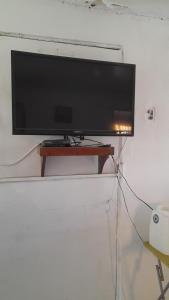 una TV a schermo piatto appesa a un muro di Hospedaje entre rokas a Huasco
