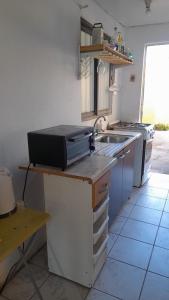 a kitchen with a sink and a microwave at Hospedaje entre rokas in Huasco