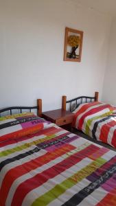 2 Betten nebeneinander in einem Zimmer in der Unterkunft Hospedaje entre rokas in Huasco