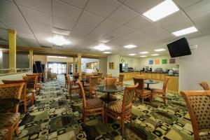 a dining room with tables and chairs and a television at Baymont by Wyndham Marion in Marion