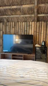 a bedroom with a flat screen tv and a bed at اكواخ البامبو in Malham