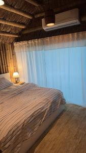 a bedroom with a large bed with a window at اكواخ البامبو in Malham