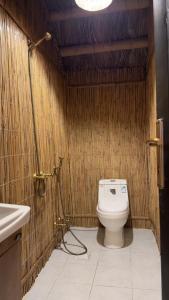 La petite salle de bains est pourvue de toilettes et d'un lavabo. dans l'établissement اكواخ البامبو, à Malham