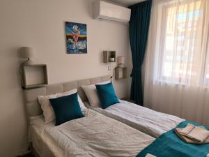 a bedroom with a bed with blue pillows and a window at Beautiful Apartment in Bansko