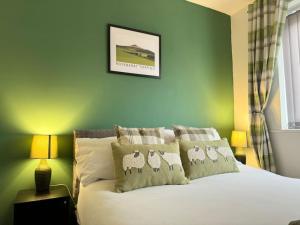 a bedroom with a bed with four sheep pillows at Hambleton Hideaway in Stokesley