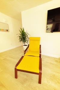 a yellow chair in an empty room with a plant at Laguna Azul - Sleeps 8 + Heated Pool + Walk to Beach in St. Pete Beach