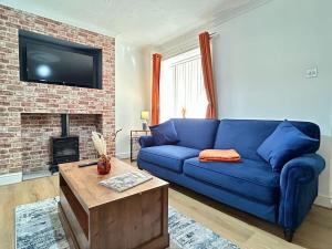 a blue couch in a living room with a fireplace at Hambleton Hideaway in Stokesley