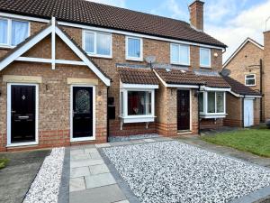 a brick house with two doors and a driveway at Hambleton Hideaway in Stokesley