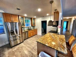 a kitchen with a stainless steel refrigerator and wooden cabinets at Laguna Azul - Sleeps 8 + Heated Pool + Walk to Beach in St. Pete Beach