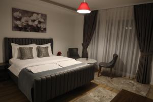 a bedroom with a large bed and a chair at Andoena Resort in Lipjan