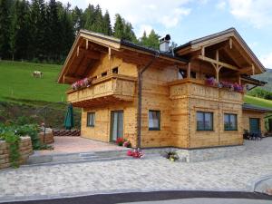 a log cabin with a porch and a roof at Ferienhaus Lechnerhof in Schladming