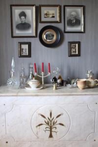 uma mesa com algumas fotos na parede e velas vermelhas em Le Rézinet - Chambres d'Hôtes em Marcilly le Chatel