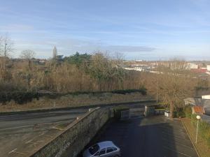 a car parked in a parking lot next to a road at Studio vue dégagée avec parking privé & balcon in Rochefort