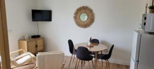 a dining room with a table and chairs and a mirror at Studio vue dégagée avec parking privé & balcon in Rochefort