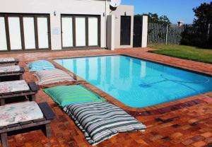 a swimming pool with pillows laying around it at Ellefsen 134 Golf Paradise - NEWLY RENOVATED! in Langebaan