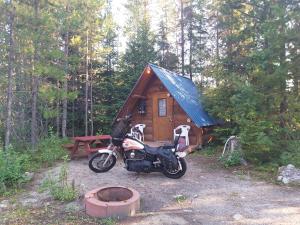 a motorcycle parked in front of a small cabin at Blue River Cabins & Campgrounds in Blue River