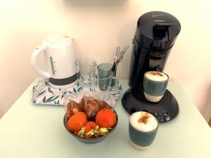 eine Theke mit einer Kaffeemaschine und einer Obstschale in der Unterkunft Chambre Sérénité avec SDB privée - 'Les 7 Sources' 
