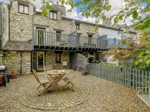 a patio with a table and chairs in front of a building at 3 Bed in Cartmel 66725 in Holker