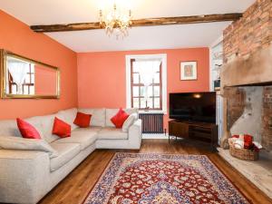 uma sala de estar com um sofá e uma televisão em Rustic Lancashire Farmhouse em Preston